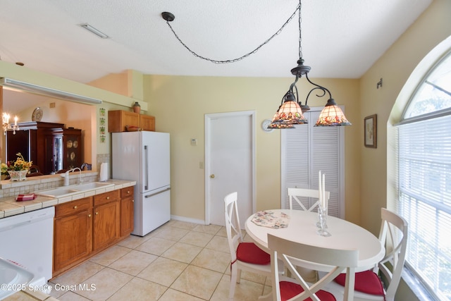 1790 Seeley Cir NW, Palm Bay, FL 32907 - kitchen with white appliances, a sink, tile counters, brown cabinets, and pendant lighting