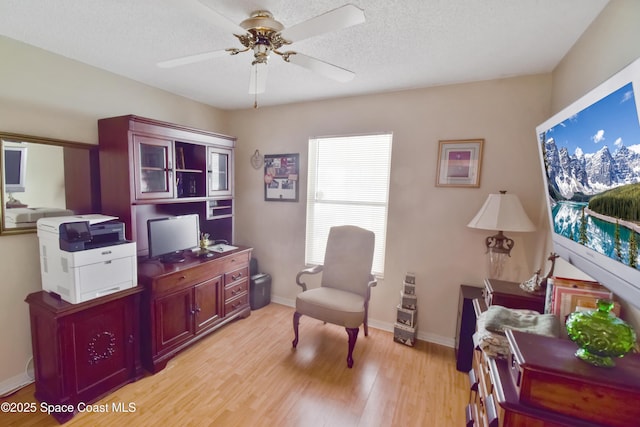 1790 Seeley Cir NW, Palm Bay, FL 32907 - living area featuring light wood-style floors, a desk, a ceiling fan, and a textured ceiling