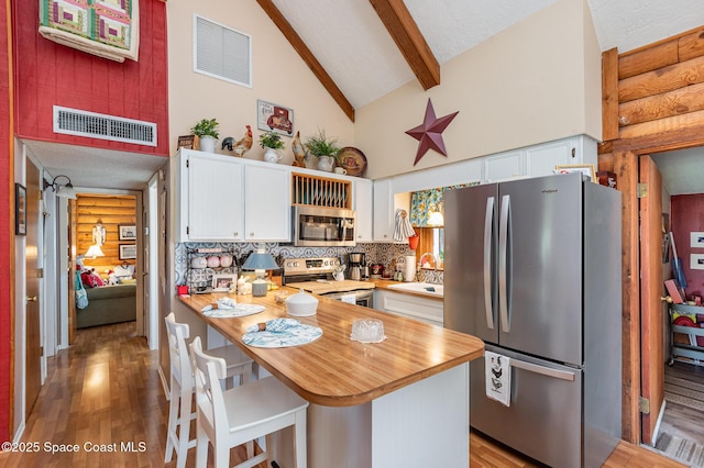 4390 Everglades St, Cocoa, FL 32927 - kitchen featuring appliances with stainless steel finishes, a sink, white cabinetry, light wood finished floors, and a peninsula