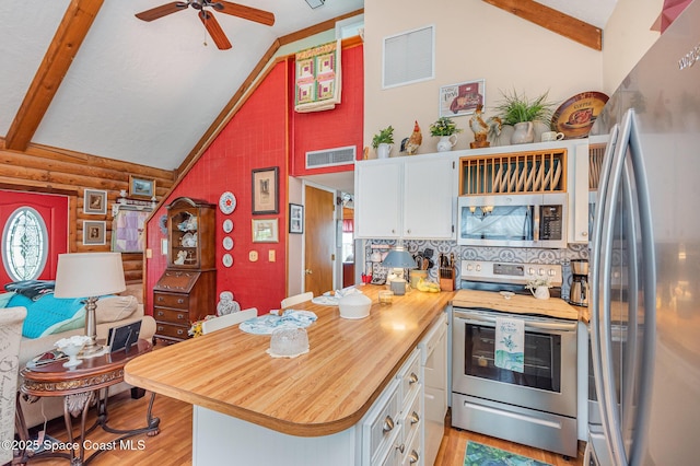 4390 Everglades St, Cocoa, FL 32927 - kitchen with stainless steel appliances, white cabinets, butcher block countertops, light wood-type flooring, and log walls