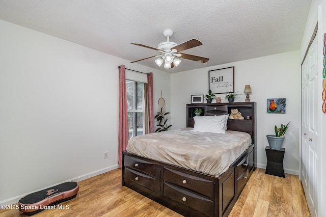 251 District St SE, Palm Bay, FL 32909 - bedroom with light wood-type flooring, baseboards, a ceiling fan, and a textured ceiling