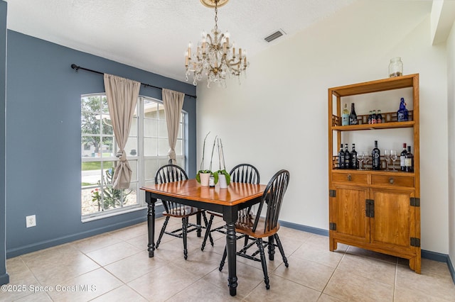 251 District St SE, Palm Bay, FL 32909 - dining room featuring a chandelier, baseboards, a textured ceiling, and light tile patterned flooring
