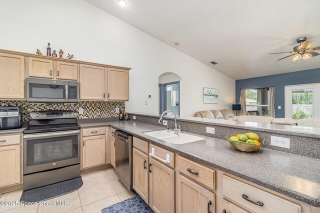 251 District St SE, Palm Bay, FL 32909 - kitchen featuring stainless steel appliances, light brown cabinets, a sink, and vaulted ceiling
