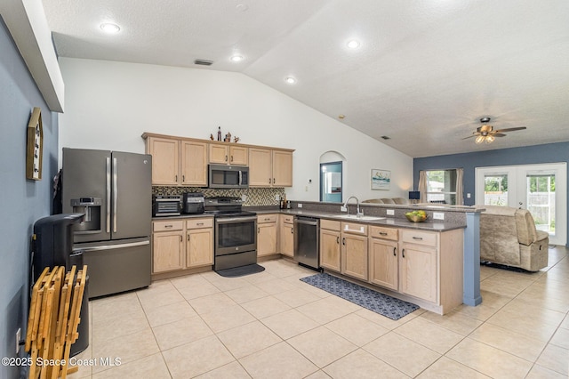 251 District St SE, Palm Bay, FL 32909 - kitchen featuring stainless steel appliances, light brown cabinets, dark countertops, a peninsula, and high vaulted ceiling