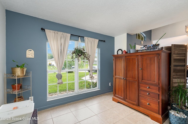 251 District St SE, Palm Bay, FL 32909 - bedroom with a textured ceiling, multiple windows, light tile patterned floors, and baseboards