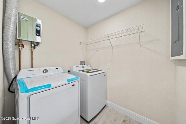 414 Marquis St, Melbourne, FL 32901 - laundry room with washer and clothes dryer, light wood-style flooring, water heater, and baseboards
