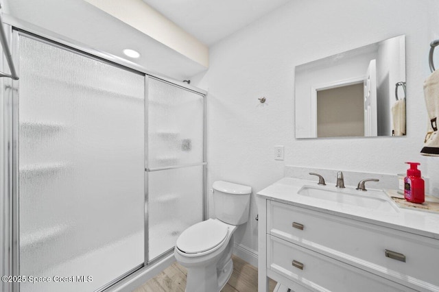 414 Marquis St, Melbourne, FL 32901 - bathroom featuring vanity, toilet, a shower stall, wood finished floors, and baseboards
