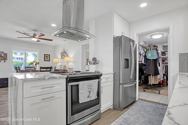326 Coral Dr, Cape Canaveral, FL 32920 - kitchen with island range hood, appliances with stainless steel finishes, white cabinets, light stone counters, and recessed lighting