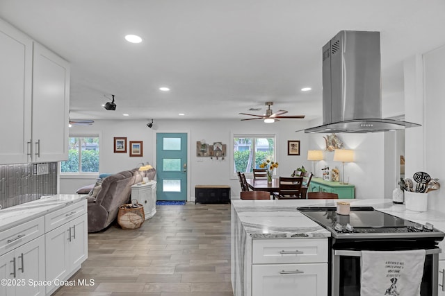 326 Coral Dr, Cape Canaveral, FL 32920 - kitchen featuring island range hood, stainless steel electric range, ceiling fan, open floor plan, and healthy amount of natural light
