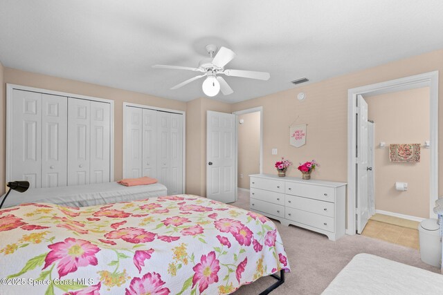 243 Forecast Ln Unit 4-21, Rockledge, FL 32955 - bedroom with multiple closets, light colored carpet, a ceiling fan, baseboards, and ensuite bathroom