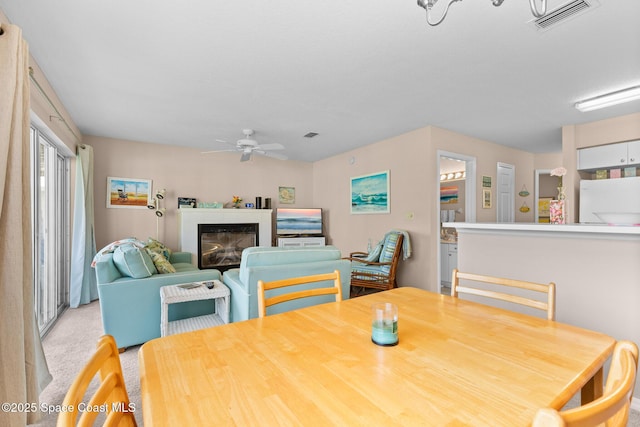 243 Forecast Ln Unit 4-21, Rockledge, FL 32955 - dining space with a ceiling fan, a glass covered fireplace, and light colored carpet
