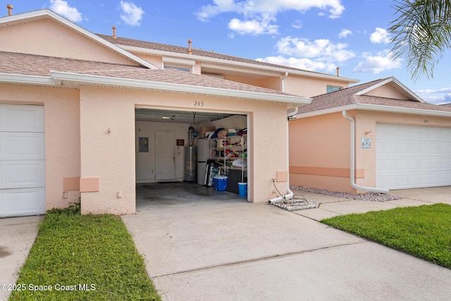243 Forecast Ln Unit 4-21, Rockledge, FL 32955 - view of front of property featuring stucco siding, driveway, electric panel, a garage, and a shingled roof