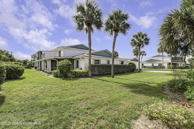 290 Paradise Blvd Unit 61, Indialantic, FL 32903 - rear view of property with a yard, stucco siding, and a balcony