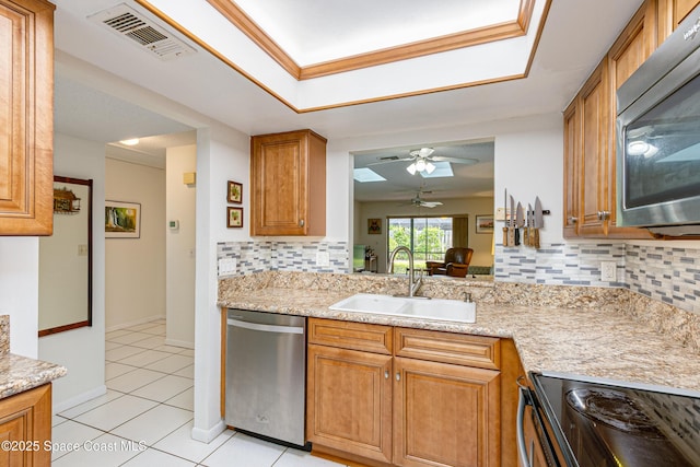 290 Paradise Blvd Unit 61, Indialantic, FL 32903 - kitchen with stainless steel appliances, a sink, decorative backsplash, light tile patterned flooring, and a ceiling fan