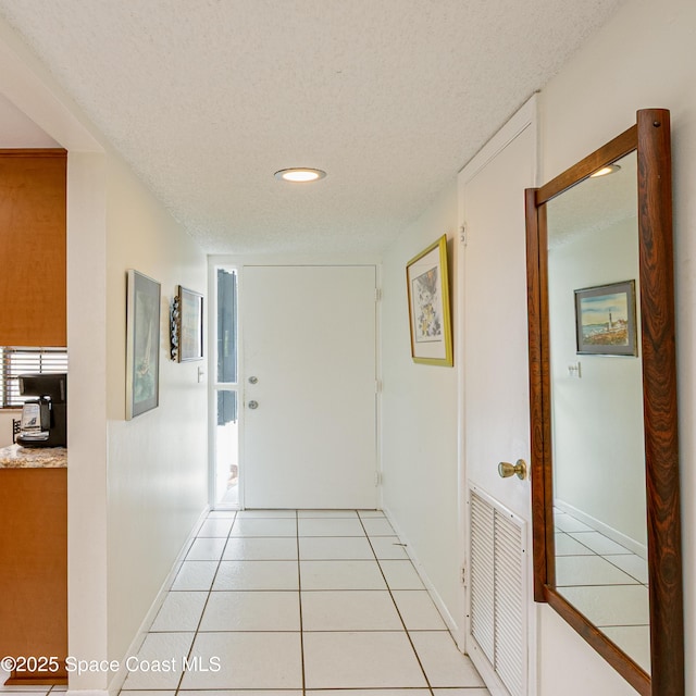 290 Paradise Blvd Unit 61, Indialantic, FL 32903 - corridor featuring a textured ceiling, baseboards, light tile patterned floors, and recessed lighting