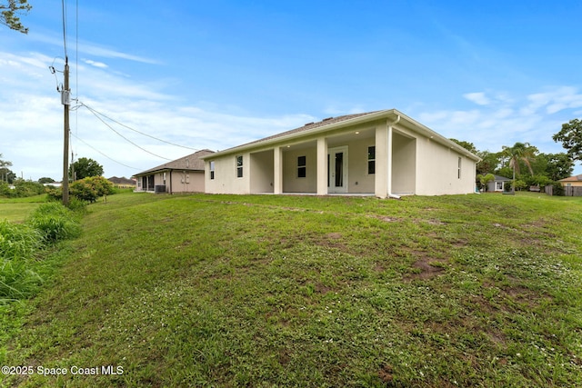 1427 Damon Rd SE, Palm Bay, FL 32909 - rear view of property with a lawn and stucco siding