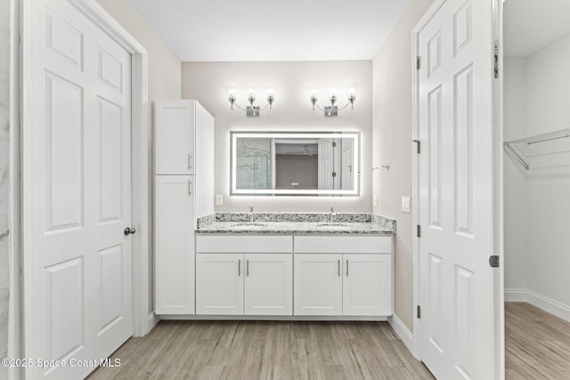 1427 Damon Rd SE, Palm Bay, FL 32909 - full bathroom featuring wood finished floors, double vanity, a closet, and baseboards