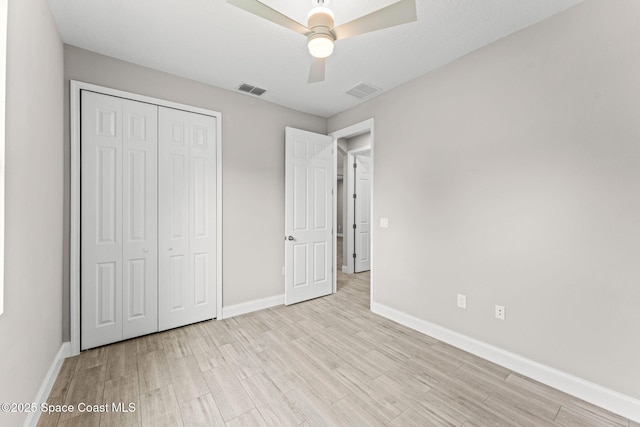 1427 Damon Rd SE, Palm Bay, FL 32909 - unfurnished bedroom featuring light wood finished floors, baseboards, and a closet