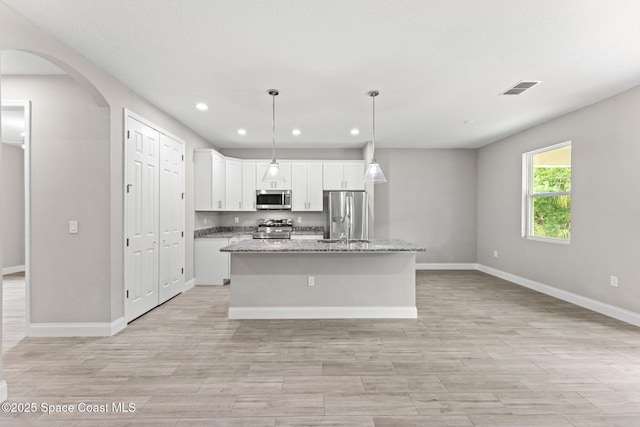 1427 Damon Rd SE, Palm Bay, FL 32909 - kitchen with appliances with stainless steel finishes, recessed lighting, arched walkways, baseboards, and white cabinetry
