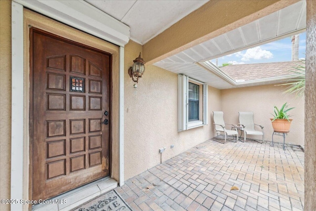 1510 Jupiter Blvd NW, Palm Bay, FL 32907 - view of exterior entry with stucco siding and a shingled roof