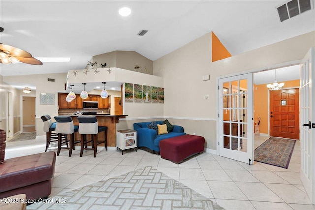1510 Jupiter Blvd NW, Palm Bay, FL 32907 - living room featuring light tile patterned floors, a chandelier, ceiling fan, and high vaulted ceiling