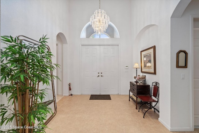 2770 Grand Isle Way SW, Vero Beach, FL 32968 - foyer entrance with a towering ceiling, arched walkways, and a chandelier