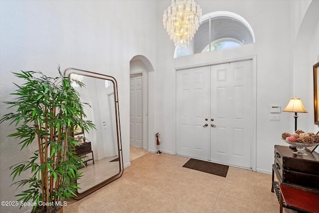 2770 Grand Isle Way SW, Vero Beach, FL 32968 - foyer featuring arched walkways, a towering ceiling, and a chandelier