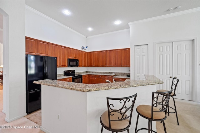 2770 Grand Isle Way SW, Vero Beach, FL 32968 - kitchen featuring black appliances, crown molding, a large island, light carpet, and brown cabinets