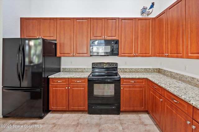 2770 Grand Isle Way SW, Vero Beach, FL 32968 - kitchen featuring black appliances, light stone countertops, and brown cabinetry