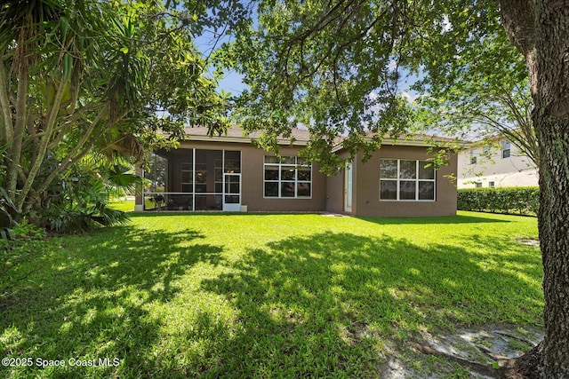 2770 Grand Isle Way SW, Vero Beach, FL 32968 - back of house with stucco siding, a lawn, and a sunroom