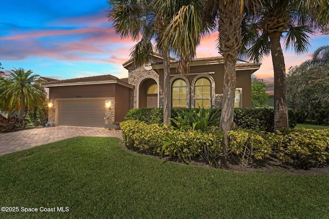2770 Grand Isle Way SW, Vero Beach, FL 32968 - mediterranean / spanish home featuring stucco siding, a garage, a yard, decorative driveway, and stone siding