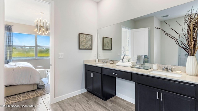 3012 Antarus Dr NW, Palm Bay, FL 32907 - ensuite bathroom featuring double vanity, a chandelier, wood tiled floors, and baseboards