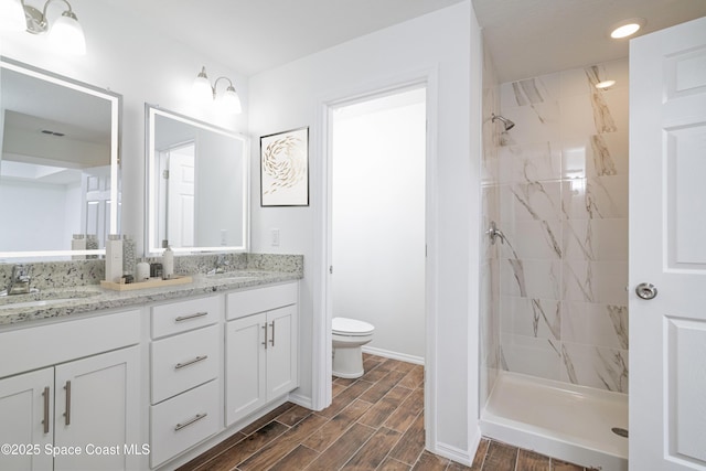 878 Reading St SE Unit 22, Palm Bay, FL 32909 - full bathroom featuring toilet, double vanity, tiled shower, wood finished floors, and baseboards