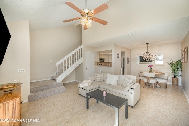 714 Players Ct, Melbourne, FL 32940 - living room with stairs, a chandelier, light tile patterned floors, vaulted ceiling, and ceiling fan