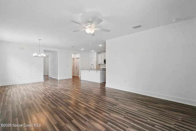 15 Ponderosa Ln, Palm Coast, FL 32164 - unfurnished living room with a ceiling fan, a chandelier, dark wood-type flooring, recessed lighting, and a sink