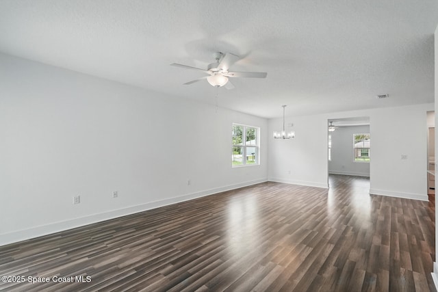 15 Ponderosa Ln, Palm Coast, FL 32164 - empty room featuring a ceiling fan, a chandelier, dark wood finished floors, healthy amount of natural light, and a textured ceiling