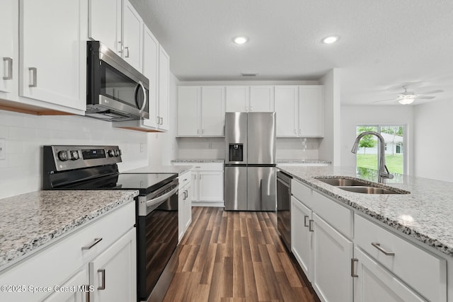 15 Ponderosa Ln, Palm Coast, FL 32164 - kitchen with stainless steel appliances, a sink, white cabinetry, decorative backsplash, and dark wood-style flooring
