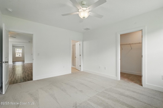 15 Ponderosa Ln, Palm Coast, FL 32164 - unfurnished bedroom with a walk in closet, carpet flooring, baseboards, ceiling fan, and a closet