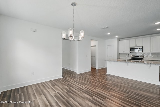 15 Ponderosa Ln, Palm Coast, FL 32164 - kitchen with stainless steel appliances, dark wood-style flooring, recessed lighting, backsplash, and a chandelier