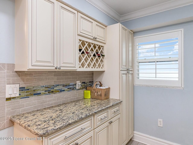 2815 S Atlantic Ave Unit 705, Cocoa Beach, FL 32931 - kitchen with cream cabinets, backsplash, light stone countertops, crown molding, and baseboards