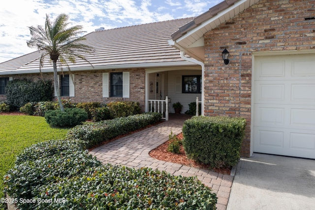 284 Andros Ave, Cocoa Beach, FL 32931 - property entrance featuring a tiled roof, an attached garage, and brick siding
