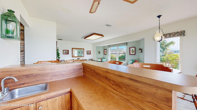 284 Andros Ave, Cocoa Beach, FL 32931 - kitchen with a sink, light countertops, decorative light fixtures, a textured ceiling, and open floor plan