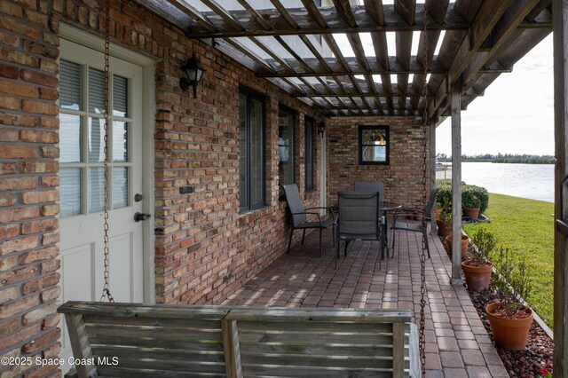 284 Andros Ave, Cocoa Beach, FL 32931 - view of patio with a water view, outdoor dining space, and a pergola
