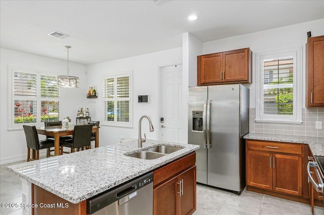 1475 Isabella Dr Unit 101, Melbourne, FL 32935 - kitchen featuring appliances with stainless steel finishes, light tile patterned flooring, light stone countertops, a kitchen island with sink, and hanging light fixtures