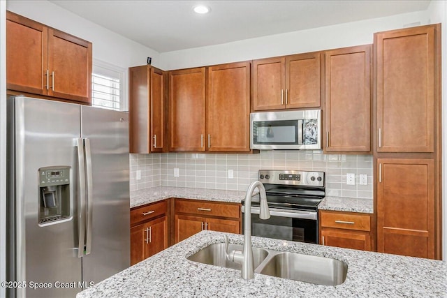 1475 Isabella Dr Unit 101, Melbourne, FL 32935 - kitchen featuring appliances with stainless steel finishes, brown cabinets, light stone countertops, backsplash, and recessed lighting