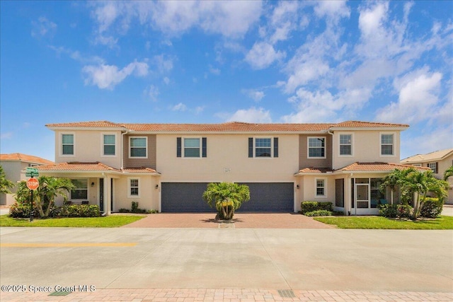 1475 Isabella Dr Unit 101, Melbourne, FL 32935 - view of front facade featuring an attached garage, a tile roof, decorative driveway, and stucco siding