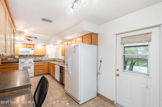957 Waialae Cir NE, Palm Bay, FL 32905 - kitchen with white appliances, a sink, a textured ceiling, dark countertops, and tasteful backsplash