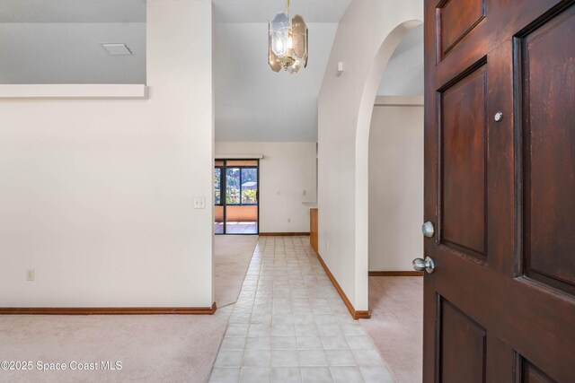 1262 Heberling St NW, Palm Bay, FL 32907 - foyer entrance with arched walkways, baseboards, light carpet, light tile patterned flooring, and high vaulted ceiling