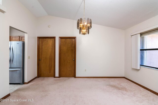 1262 Heberling St NW, Palm Bay, FL 32907 - unfurnished dining area featuring light colored carpet, a chandelier, vaulted ceiling, and baseboards