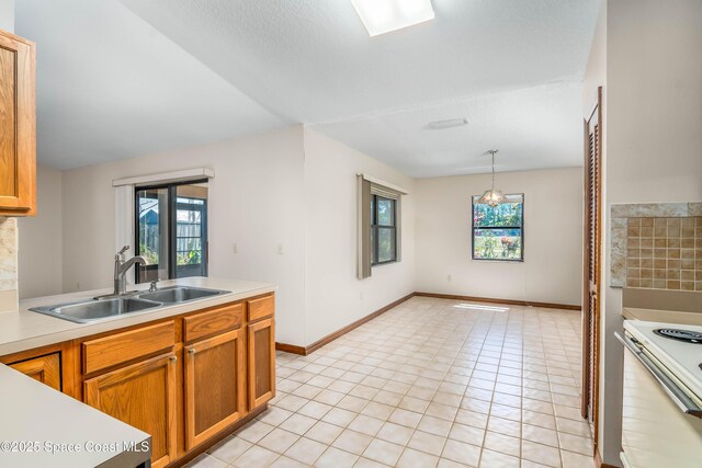 1262 Heberling St NW, Palm Bay, FL 32907 - kitchen with a sink, electric stove, light countertops, and brown cabinets